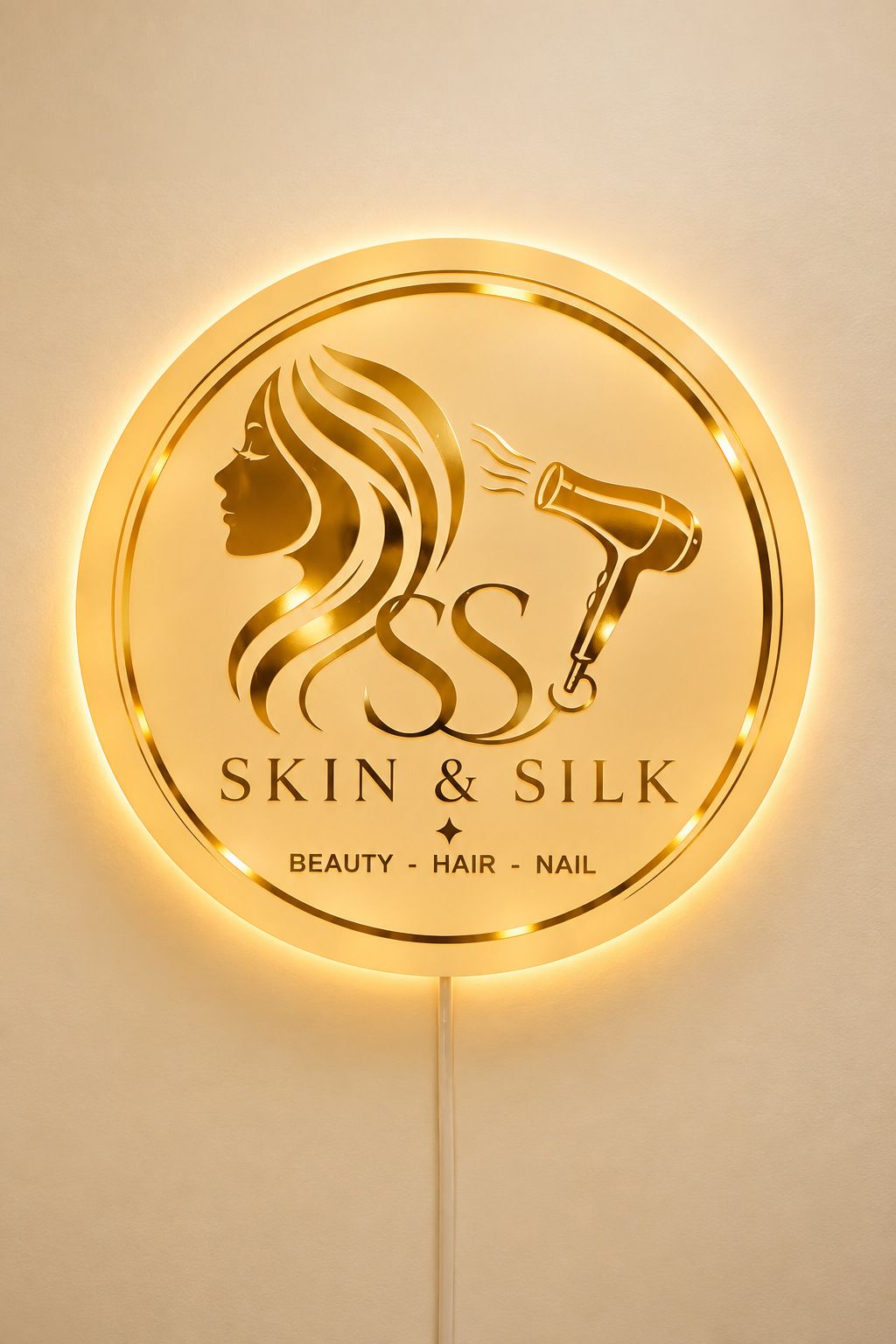 The illuminated gold Skin & Silk logo sign