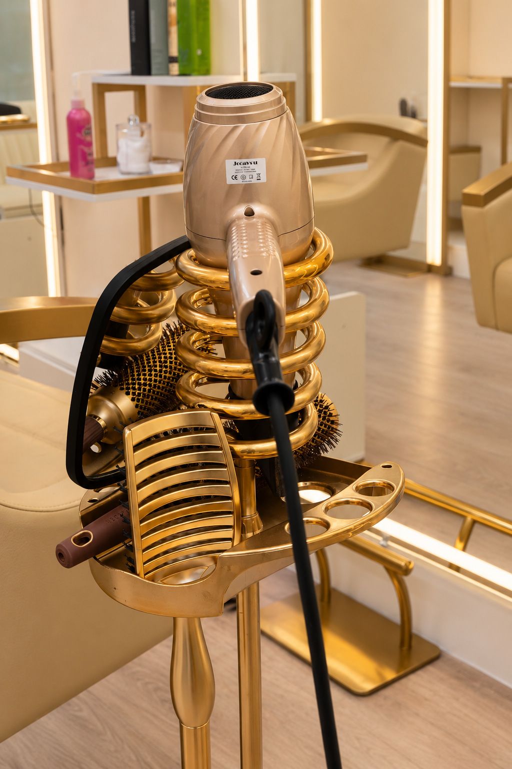A gold hairdryer holder with brushes beside a styling chair