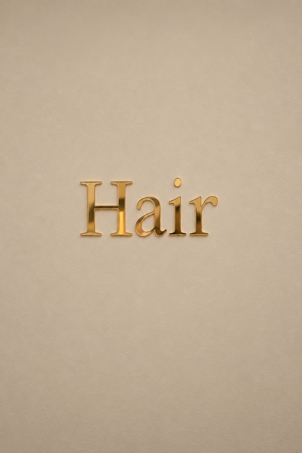 Gold Hair lettering on a cream salon wall